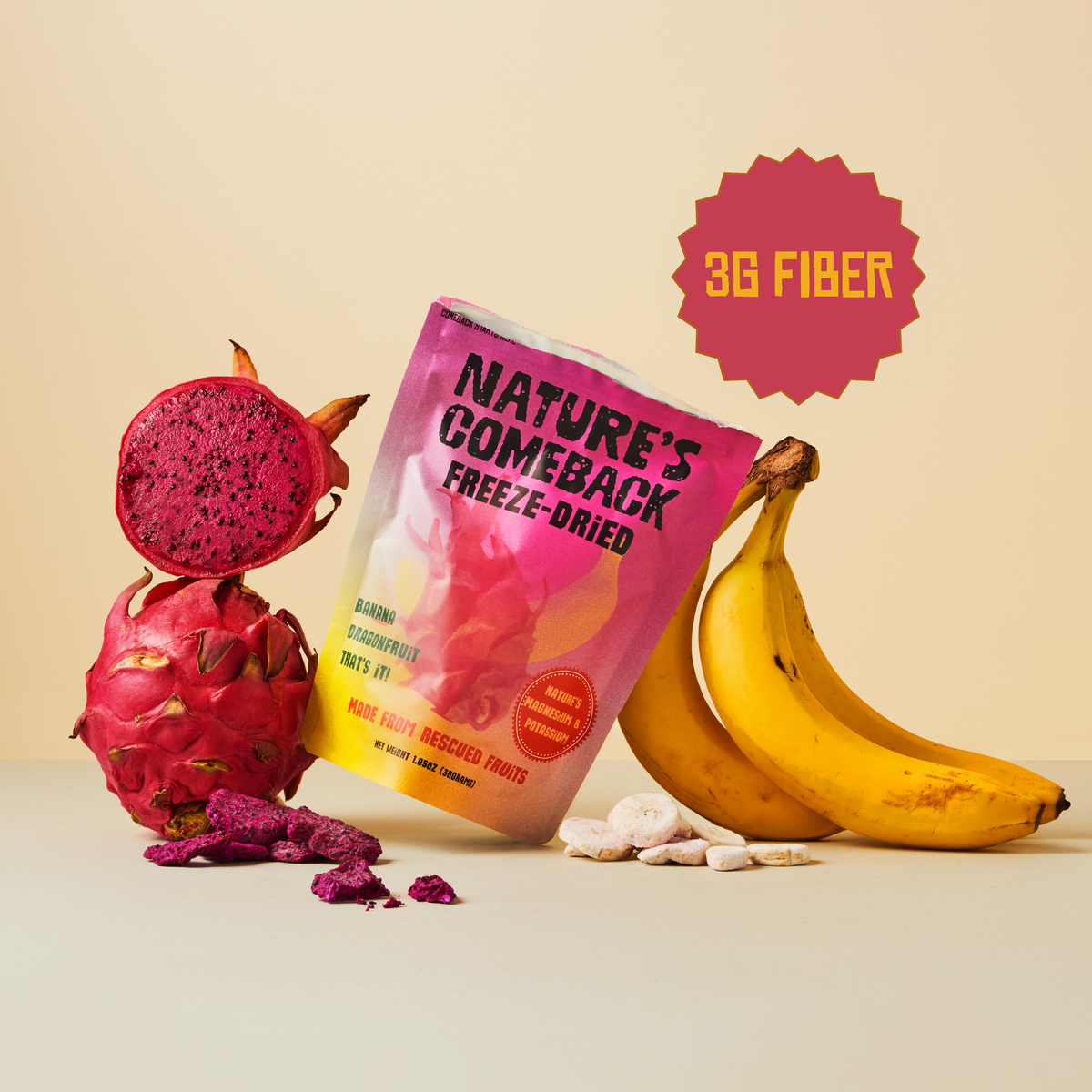 A bag of Nature's Comeback Freeze-Dried Fruits, flavor Banana Dragon Fruit, styled with a whole dragon fruit, a sliced dragon fruit, loose dried fruit pieces, and two bananas on a beige background with a '3G FIBER' badge.